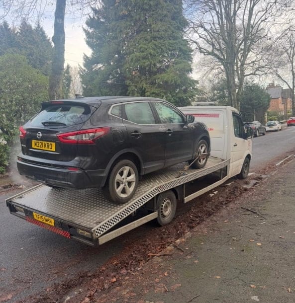 A white flatbed tow truck provides roadside breakdown recovery West Bromwich for a black Nissan SUV