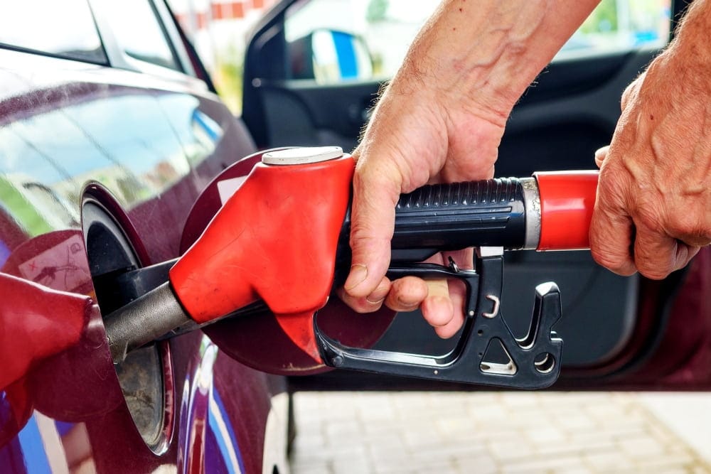 Emergency service worker uses red pump to fuel deliver to stranded car