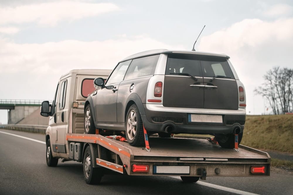Towing service moving a small car to estimate van commercial vehicle recovery