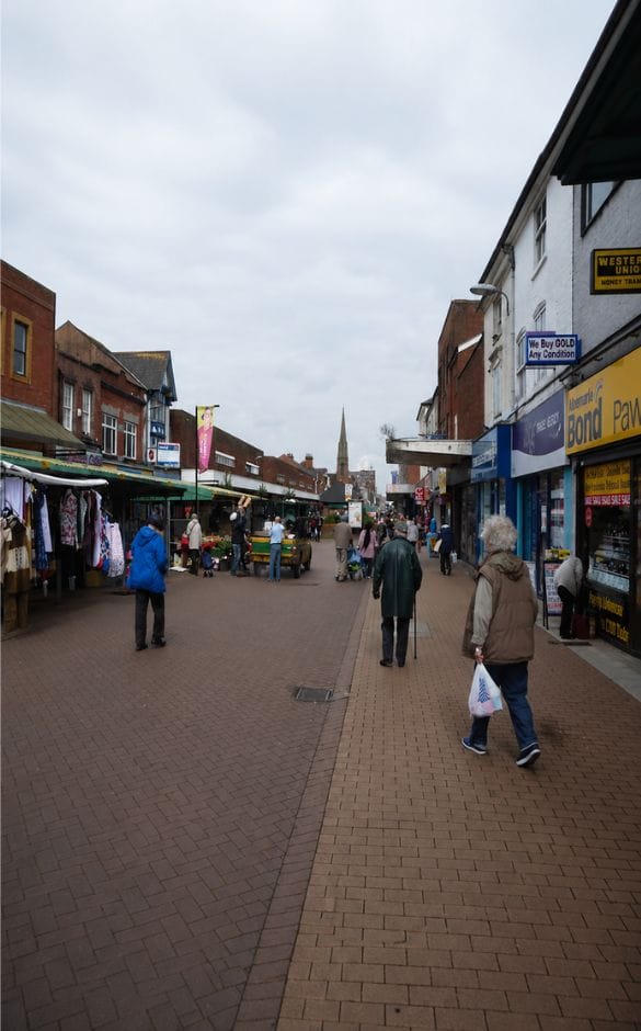 Pedestrians walk along high street providing breakdown recovery in Sandwell towns