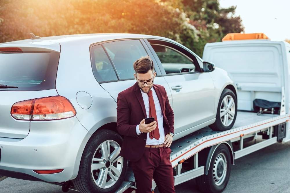 Man checks phone following vehicle breakdown near Spaghetti Junction M6 highway area