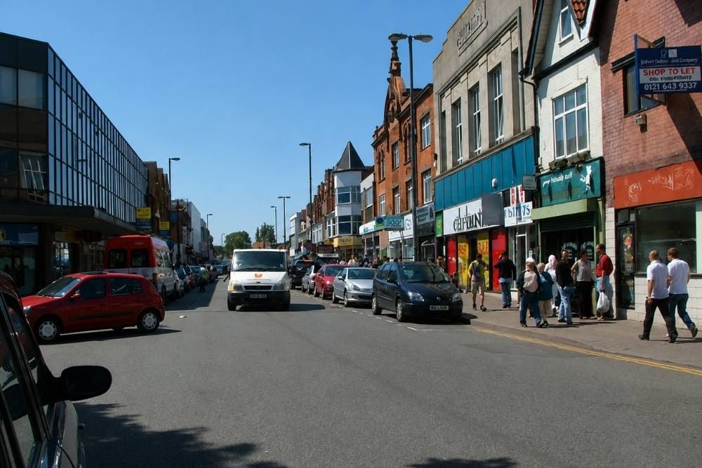 Vehicles drive along high street providing breakdown recovery services Erdington local access