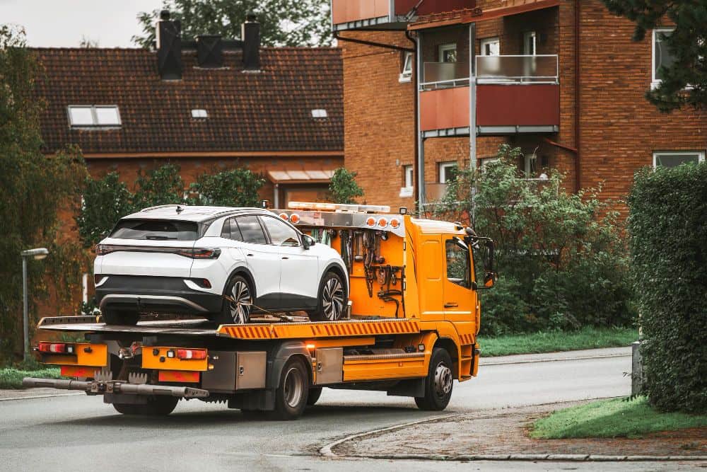 Reliable car breakdown recovery in Kings Heath transports white crossover on yellow tow truck