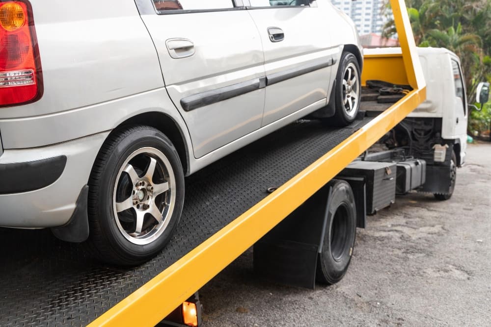 Car being loaded onto a flatbed recovery truck for vehicle recovery