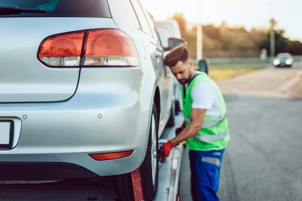 Professional secures silver car wheel for car breakdown recovery Selly Oak